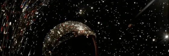 A single lit arc suspended in a dark starfield with streaks of light passing on one side: one signal worth reading among a great deal of noise.
